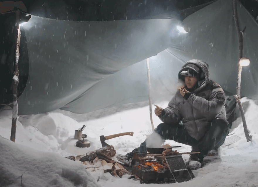 Solo camper using lightweight gear in a snowy landscape